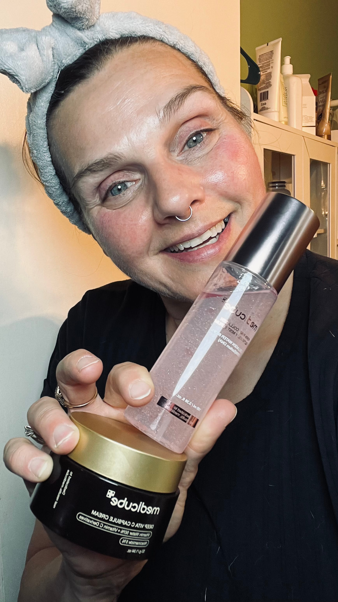 Candice filming a skincare review holding two products